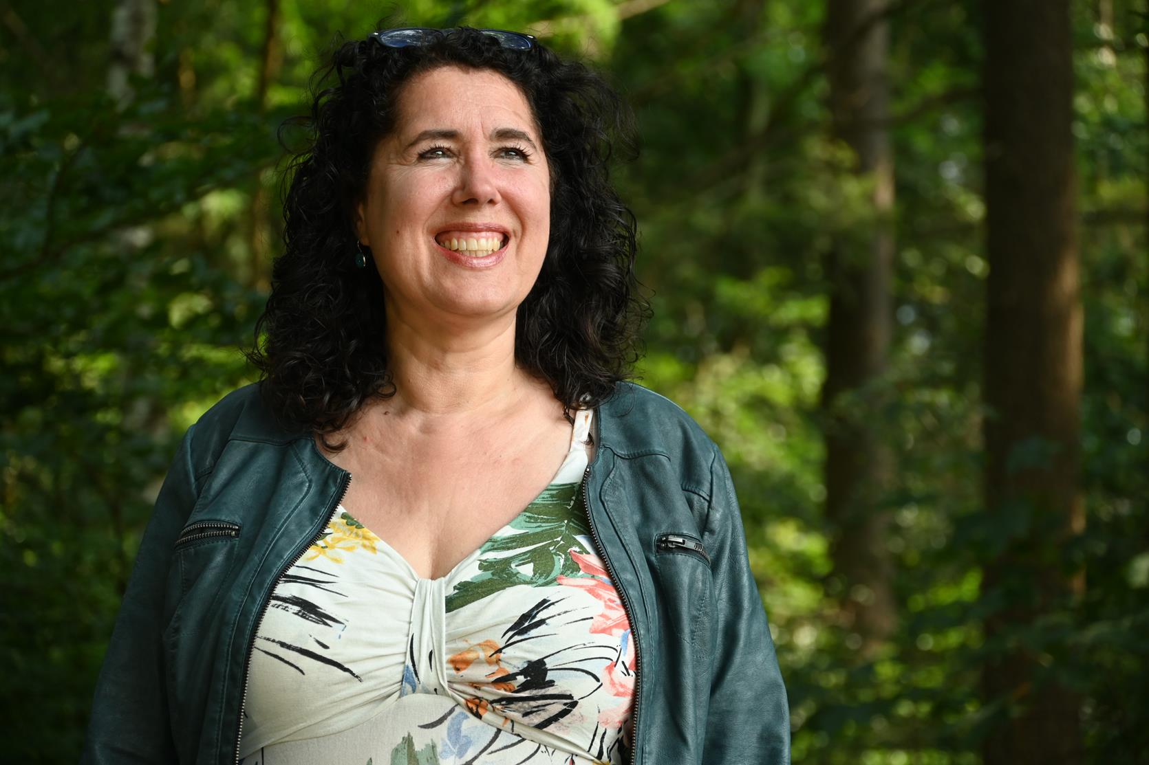 Petra in bloemenjurk met bos achtergrond